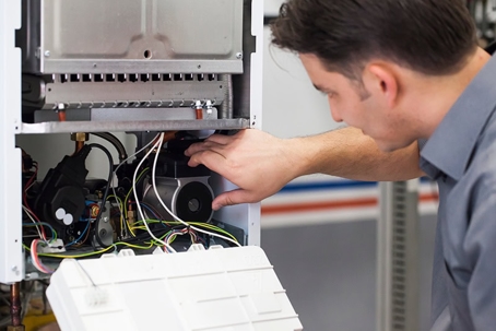 A technician repairs a boiler.